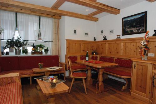 a dining room with a table and benches and a table and chairs at Pension Appartements Gabriele in Bad Gastein