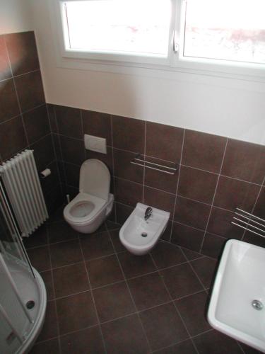 a bathroom with a toilet and a sink at "Il Terrazzo" Apartment in Colico