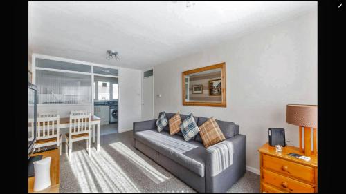 a living room with a couch and a table at Lovely One Bedroom Apartment in Stratford in London