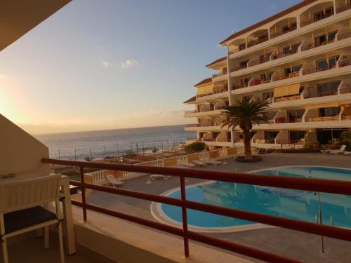 ein Balkon eines Hotels mit Swimmingpool und Meer in der Unterkunft Luxury Tagara Beach in Puerto de Santiago