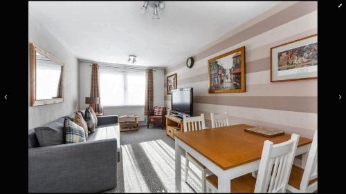 a living room with a couch and a dining room table at Lovely One Bedroom Apartment in Stratford in London