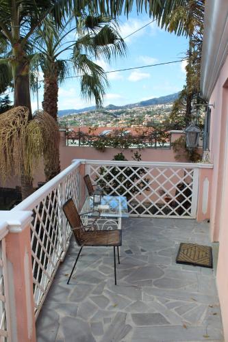 a balcony with a chair and a view of a city at Casa do Poço Funchal in Funchal