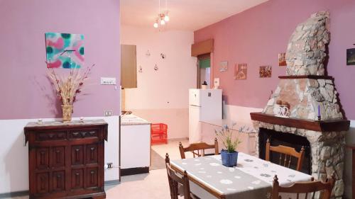 a kitchen and dining room with a table and a fireplace at Casa degli Ulivi in Gela