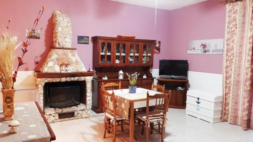 a living room with a table and a fireplace at Casa degli Ulivi in Gela