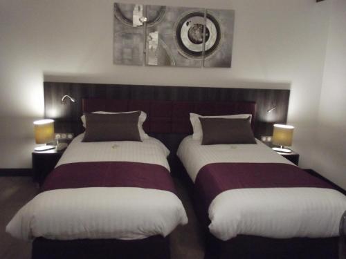 two beds sitting next to each other in a room at Le Domaine des Oliviers in Pierrelatte