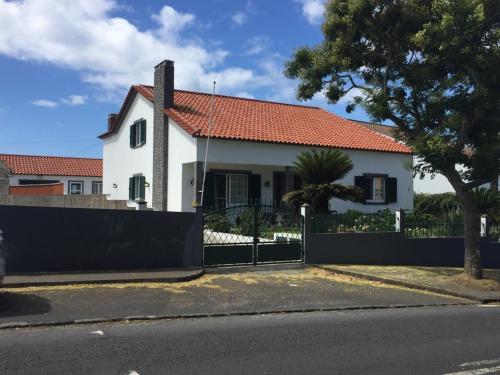 a white house with a red roof and a fence at Vivenda Garcia Bed and Breakfast in Relva