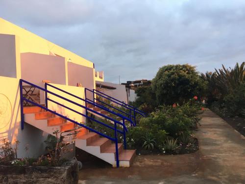 a staircase with blue railing next to a building at Apartamentos y Habitaciones Villa Marina in La Caleta