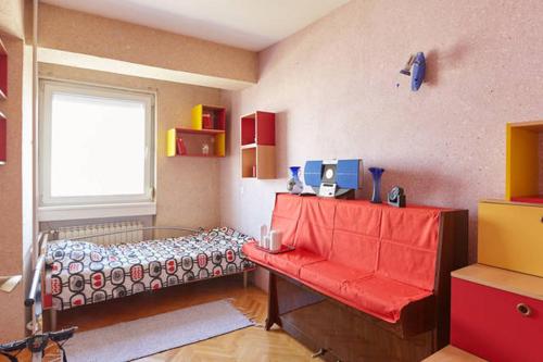 um quarto com uma cama, uma janela e um banco vermelho em Perfect reflection em Skopje