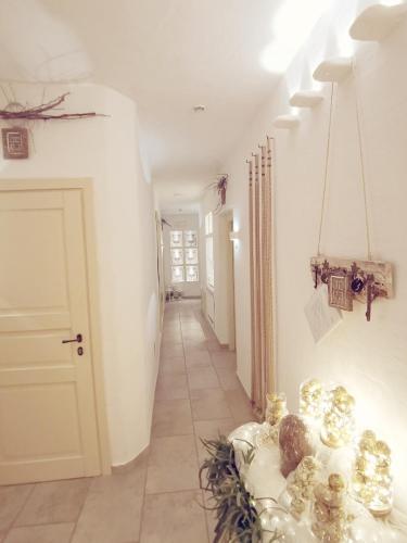 a hallway with a room with white walls and a door at Le Nicchie Guest House in Lucera