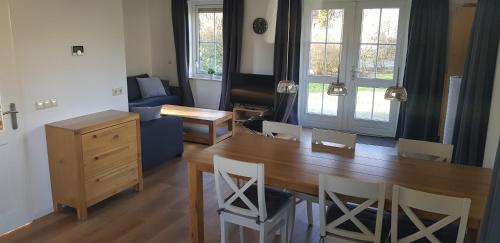a living room with a wooden table and chairs at Salland Vakantie in Heeten