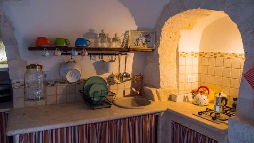 a kitchen with a counter top with a sink at Trulli Barsento in Alberobello