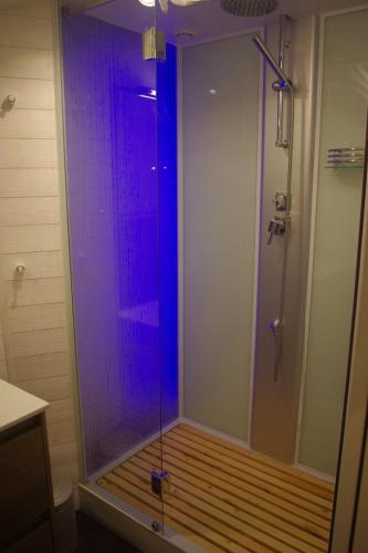 une douche avec une porte vitrée dans une salle de bain dans l'établissement Typique maison en coeur de village proche des plages, à Sainte-Marie-la-Mer