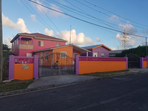 a house with a colorful fence on a street at Tequila Sunrise Antigua in Osbourn