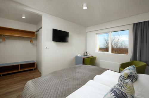 um quarto com uma cama e uma televisão na parede em Hotel Klaustur em Kirkjubæjarklaustur