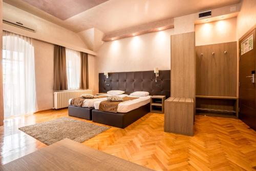 a bedroom with a large bed in a room at Hotel Fontana in Novi Sad