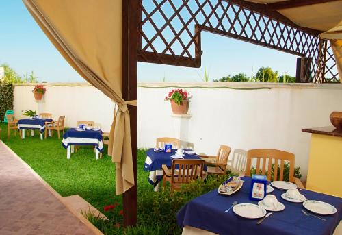 a patio with tables and chairs with blue table cloth at Salento Terra Maris in Cocumola