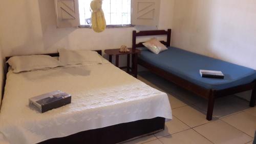 a small room with two beds and a window at Casa de praia em Atalaia in Luis Correia