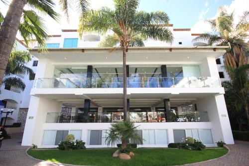 a building with palm trees in front of it at Hotel Gran Plaza & Convention Center in Guanajuato
