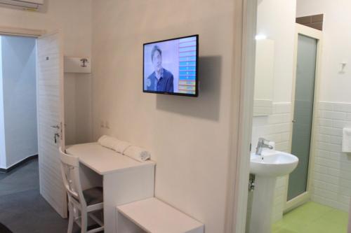 bagno con lavandino e TV a parete di B&B Alambrado Rooms & Suites a Napoli