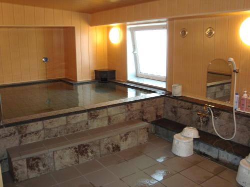ein großes Bad mit einer Badewanne und einer Dusche in der Unterkunft Hotel Route-Inn Gifuhashima Ekimae in Hashima