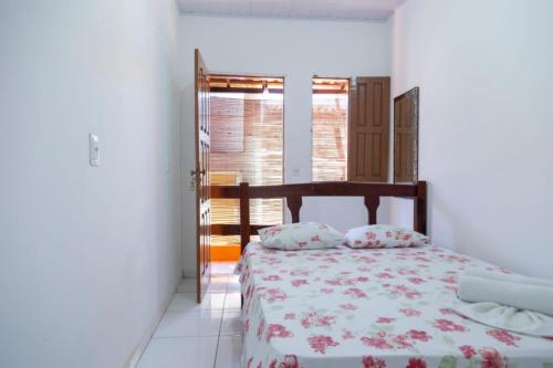 um quarto com uma cama e uma janela em Pousada & Kitnet Nascer do Sol na Ilha de Boipeba