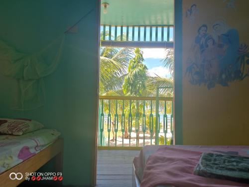 a bedroom with a window with a view of a yard at Valine Grace Cottages in El Nido