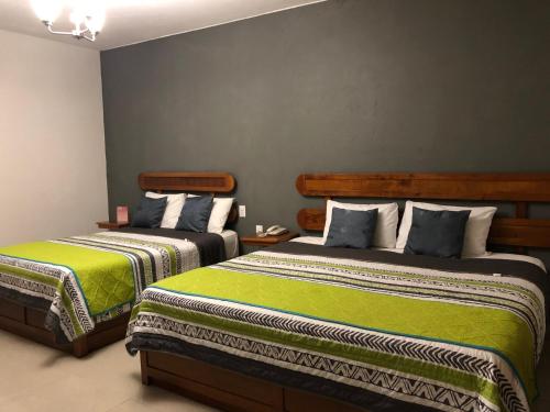 1 dormitorio con 2 camas con sábanas verdes en Hotel Pastora, en Córdoba