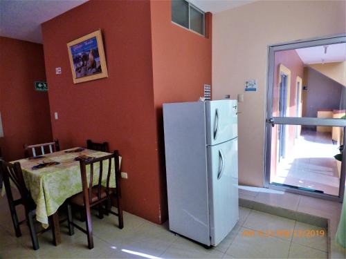 a kitchen with a table and a white refrigerator at Hostal Terito in Puerto Baquerizo Moreno