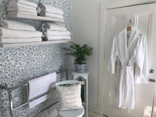 a bathroom with white towels on a rack and a door at Newfield Mews in Ayr