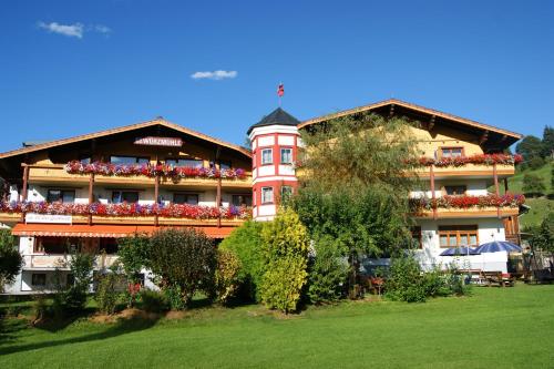 a large building with flowers on the balconies of it at Ferienhotel Gewürzmühle in Radstadt