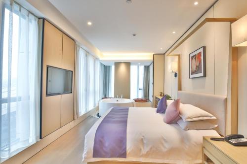 a bedroom with a large bed and a television at SSAW Boutique Hotel Wenzhou Jiushan Lake in Wenzhou