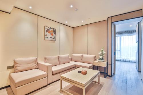 a living room with a couch and a table at SSAW Boutique Hotel Wenzhou Jiushan Lake in Wenzhou