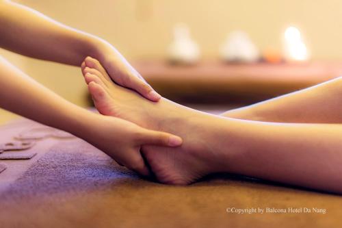 two girls are holding their feet on a table at Balcona Hotel Da Nang in Da Nang