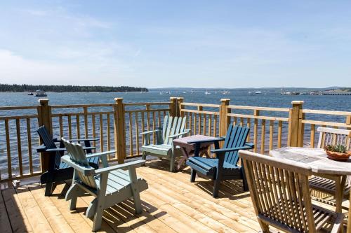 a deck with four chairs and a table and a table and chairsktop at Seaside Beach Resort in Saint Andrews