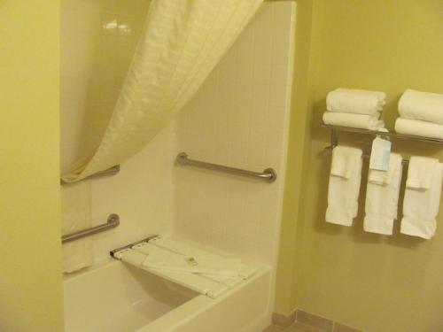 a bathroom with a tub and a toilet and towels at Cobblestone Inn & Suites - Ambridge in Ambridge