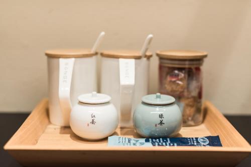 a wooden tray with three vases and jars on it at Yunshan Villa in Huangshan Scenic Area