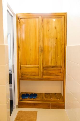 a wooden cabinet in the corner of a bathroom at Mui Ne Beach Hotel in Mui Ne