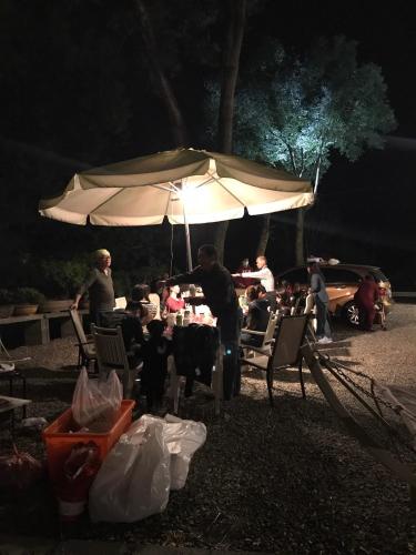 a group of people sitting at a table under an umbrella at 800 Lan Homestay in Zhushan