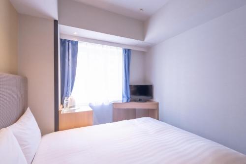 Postel nebo postele na pokoji v ubytování E Hotel Higashi Shinjuku