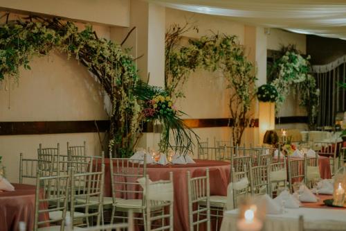 un salón de banquetes con mesas y sillas con flores en Reyna's the Haven & Gardens en Tagbilaran City