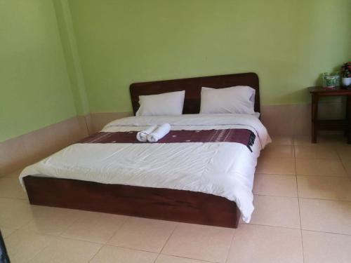 a bed in a bedroom with a white object on it at Arthith Guesthouse in Nongkhiaw
