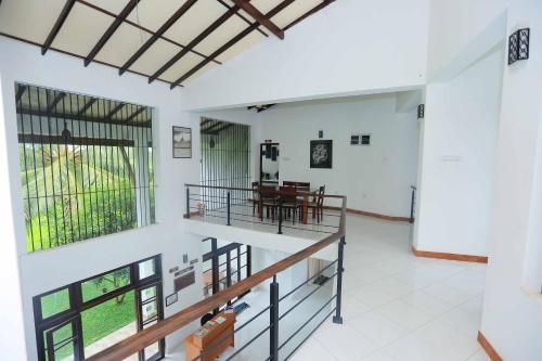 a living room with a staircase and a dining room at Serene View Tourist Rest in Anuradhapura