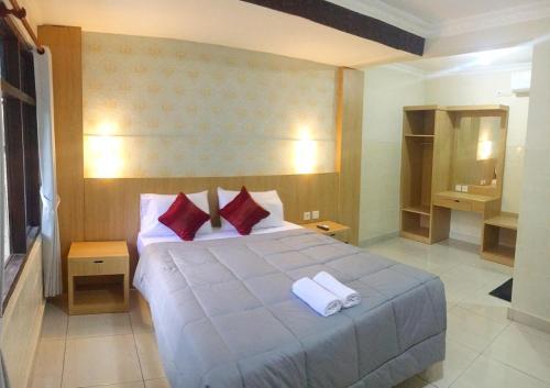 1 dormitorio con 1 cama grande y 2 toallas. en Dewa Bharata Bungalows Legian, en Legian