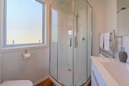 un baño con ducha y lavabo en Tipi Haere, en Nelson