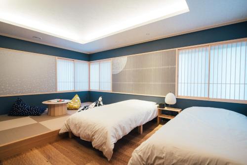 two beds in a room with blue walls at 礎旅音 in Kanazawa