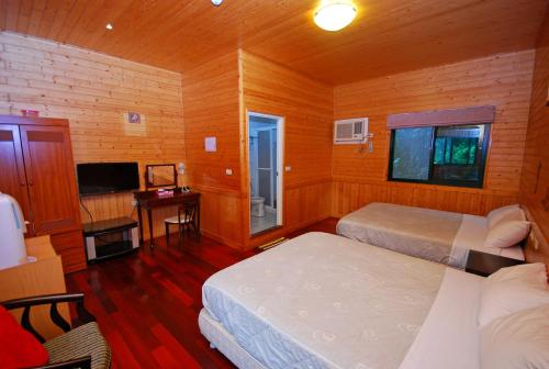 南庄的住宿－鳳櫻碧山莊，一间卧室配有两张床和电视。