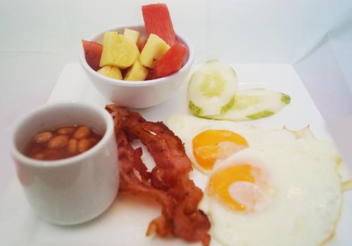 a plate of breakfast food with eggs bacon beans and fruit at Nigi Nigi Nu Noos 'e' Nu Nu Noos in Boracay