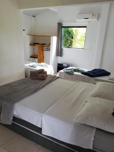 two beds in a room with a window at Pousada Tulum in Barra Grande