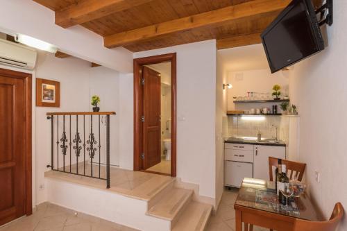 a kitchen with a table and a television on a wall at Apartments Ivana in Dubrovnik