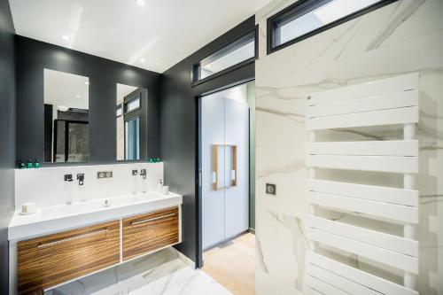 a bathroom with a sink and a mirror at Les Suites 7 Anges - Parking, Vue Cathédrale & Centre Historique Reims in Reims